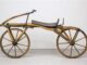 Historisches zweirädriges Holzfahrrad mit Sattel und großen Speichenrädern
